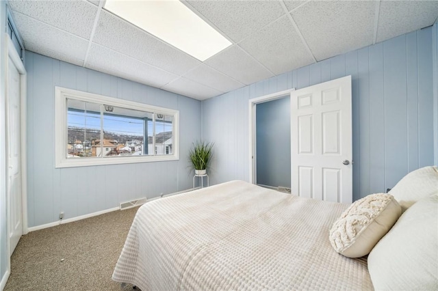 carpeted bedroom featuring a paneled ceiling