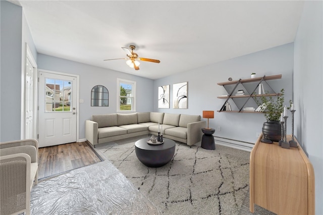 living room featuring a baseboard heating unit, light hardwood / wood-style flooring, and ceiling fan