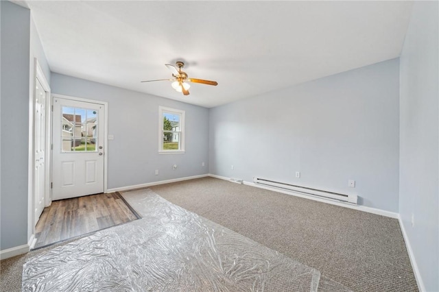 empty room featuring a baseboard heating unit, carpet floors, and ceiling fan