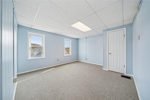 unfurnished room featuring light colored carpet and a drop ceiling