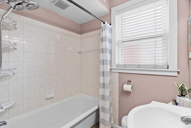 full bathroom with sink, shower / bathtub combination with curtain, and toilet