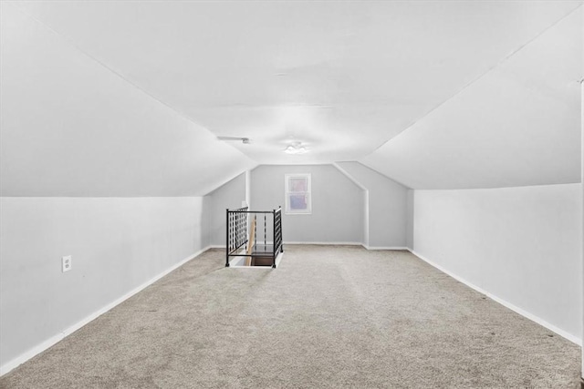 additional living space with vaulted ceiling and light colored carpet