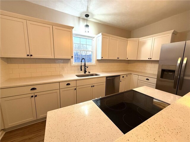 kitchen with pendant lighting, sink, tasteful backsplash, and stainless steel appliances