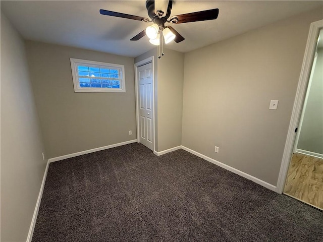 unfurnished bedroom featuring dark carpet, a closet, and ceiling fan