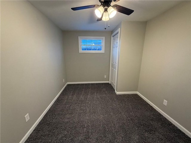 empty room featuring ceiling fan and dark colored carpet