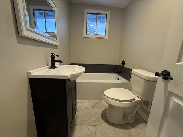 bathroom with vanity, a bathtub, and toilet