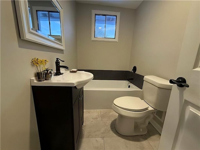 bathroom with vanity, a bath, and toilet