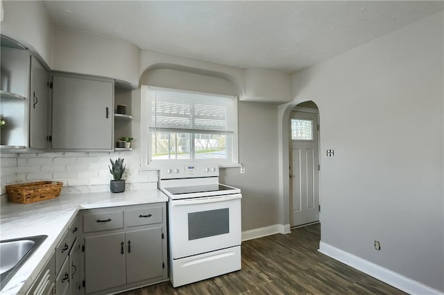 kitchen with sink, gray cabinets, white range with electric cooktop, dark hardwood / wood-style floors, and decorative backsplash