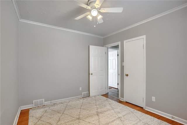 spare room featuring hardwood / wood-style flooring, crown molding, and ceiling fan