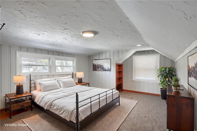 carpeted bedroom featuring lofted ceiling and a textured ceiling