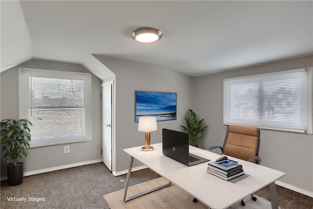 carpeted office space featuring lofted ceiling