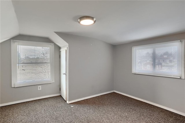 bonus room with vaulted ceiling and carpet floors