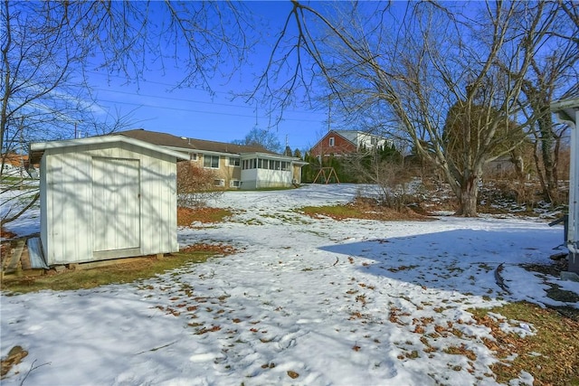 yard covered in snow with a storage unit