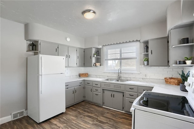 kitchen with white appliances, dark hardwood / wood-style floors, gray cabinets, and sink