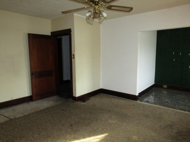 unfurnished room with ceiling fan and dark carpet