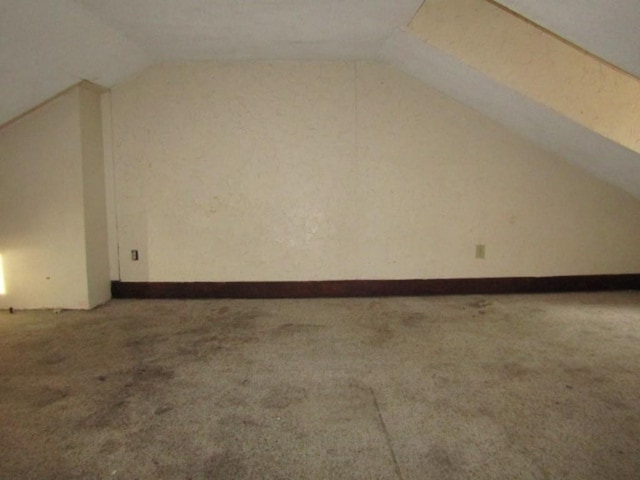 additional living space featuring lofted ceiling and carpet floors