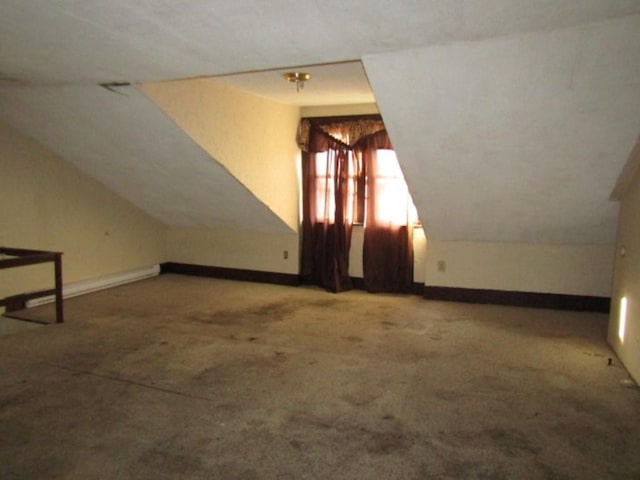 bonus room with vaulted ceiling and carpet