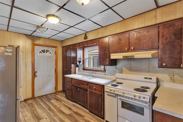 kitchen with sink, a paneled ceiling, stainless steel fridge, white range with electric stovetop, and light hardwood / wood-style floors