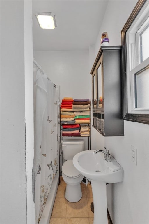 bathroom featuring tile patterned flooring, sink, a shower with shower curtain, and toilet