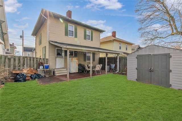 back of property with a yard, a patio area, and a shed