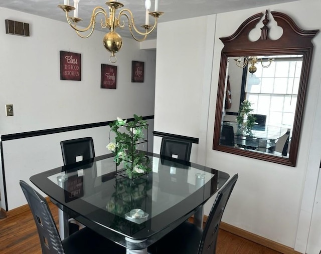 dining space with a notable chandelier and dark hardwood / wood-style flooring