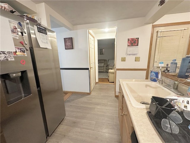 kitchen featuring sink, light wood-type flooring, and stainless steel fridge with ice dispenser