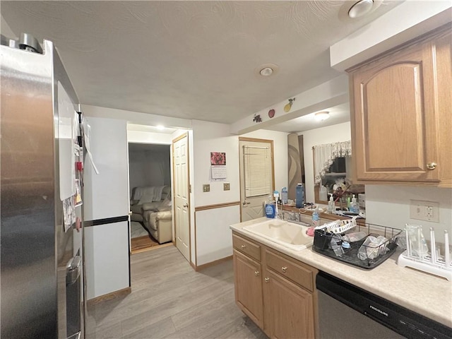 kitchen featuring stainless steel dishwasher, light brown cabinetry, light hardwood / wood-style floors, and sink