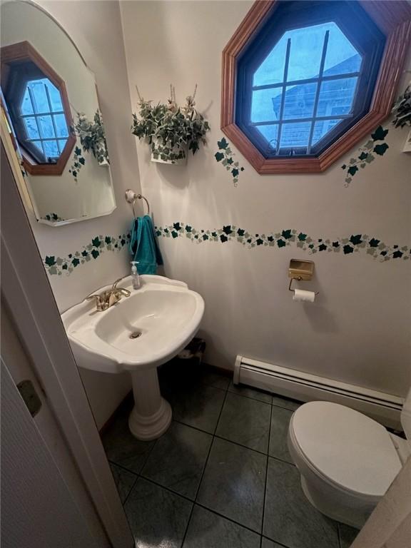 bathroom featuring a baseboard radiator, tile patterned floors, and toilet