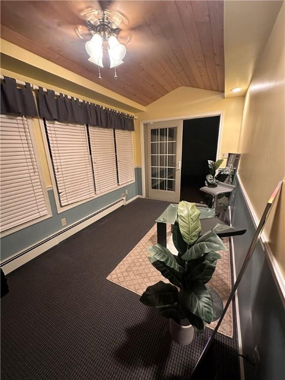 unfurnished sunroom featuring ceiling fan, a baseboard radiator, vaulted ceiling, and wooden ceiling