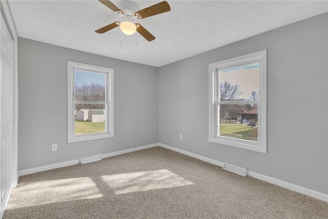 spare room with ceiling fan, a textured ceiling, and carpet