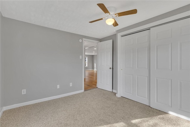 unfurnished bedroom featuring ceiling fan, a closet, and light carpet