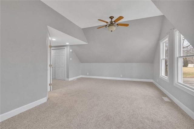 additional living space featuring ceiling fan, light colored carpet, and lofted ceiling