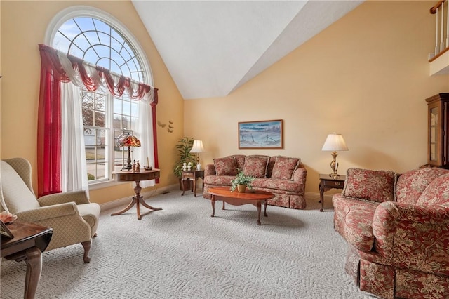 carpeted living room featuring high vaulted ceiling