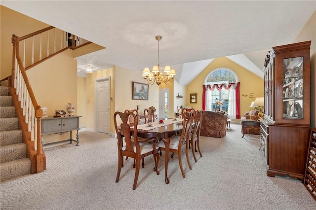 dining room featuring lofted ceiling, carpet flooring, and a chandelier