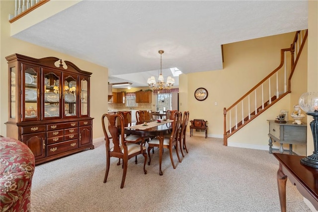 dining area featuring light colored carpet and a chandelier