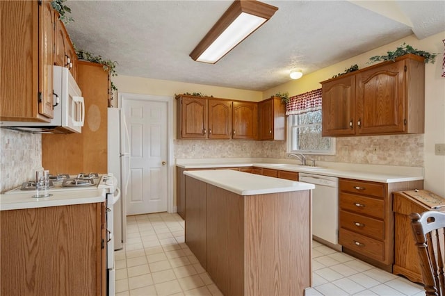 kitchen with a kitchen island, sink, backsplash, light tile patterned floors, and white appliances