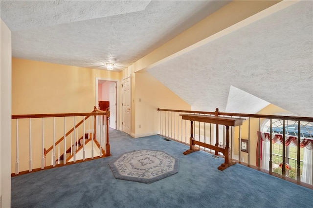 additional living space featuring lofted ceiling, carpet floors, and a textured ceiling