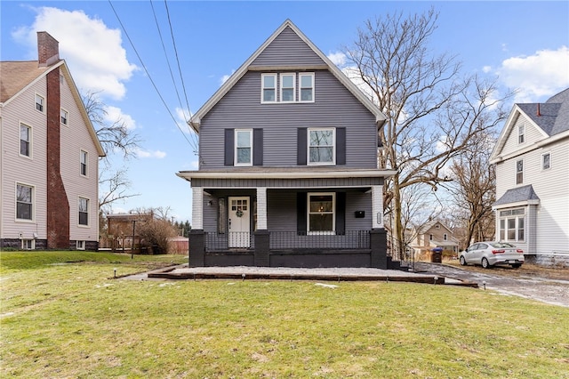 view of property featuring covered porch and a front lawn