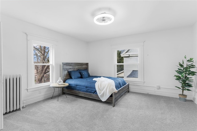 bedroom with radiator heating unit and light colored carpet