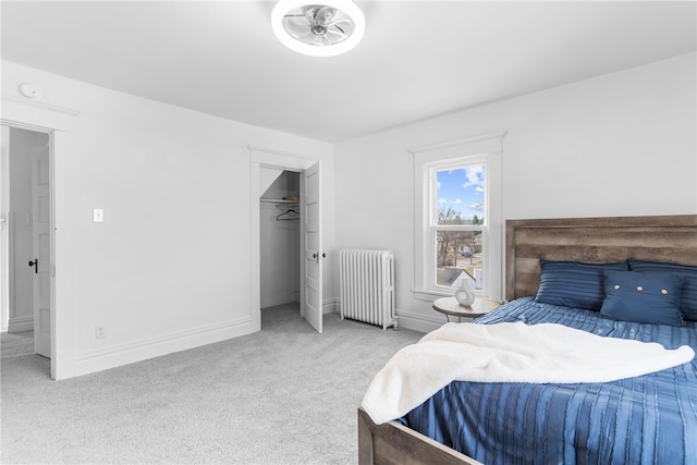 bedroom featuring radiator, light colored carpet, and a closet