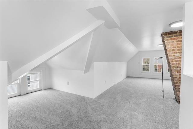 additional living space with lofted ceiling and light carpet