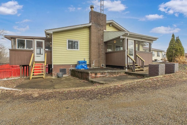 back of property with a patio and a sunroom