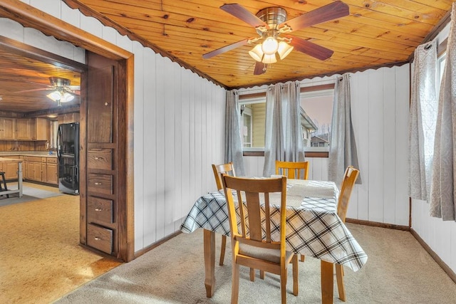 dining space with light colored carpet, wooden ceiling, and ceiling fan