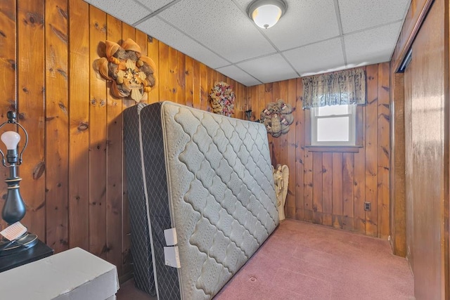 bathroom with a drop ceiling and wooden walls