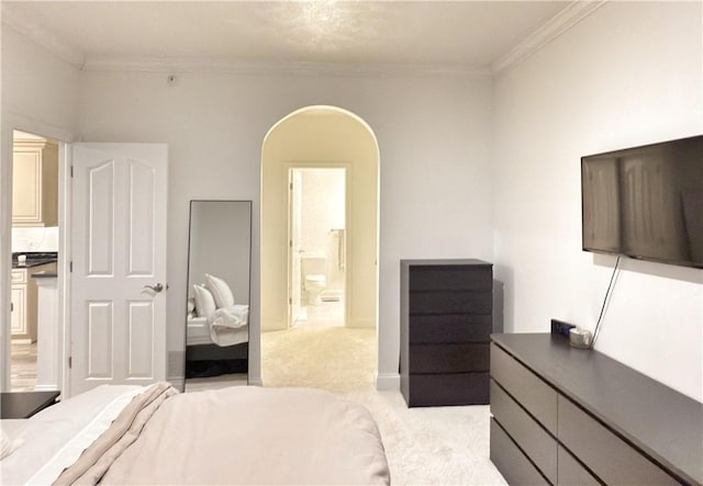 carpeted bedroom featuring crown molding and ensuite bathroom