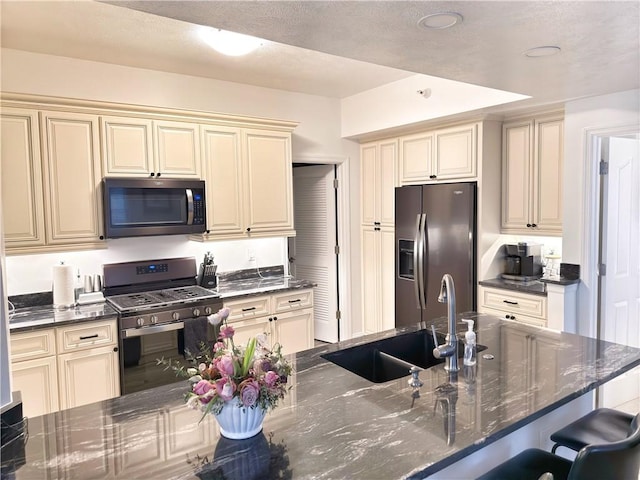 kitchen with sink, stainless steel appliances, and cream cabinetry