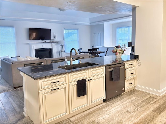 kitchen featuring sink, dishwasher, kitchen peninsula, light hardwood / wood-style floors, and cream cabinetry