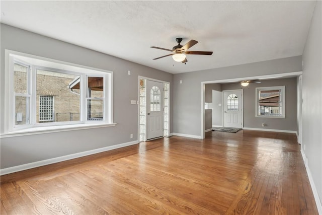 unfurnished living room with wood-type flooring and ceiling fan