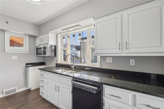 kitchen with white cabinetry, sink, dishwashing machine, and dark stone counters