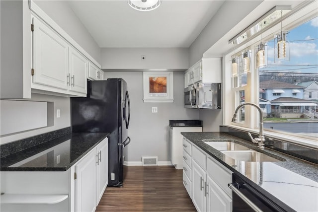 kitchen with white cabinetry, sink, and dark stone counters